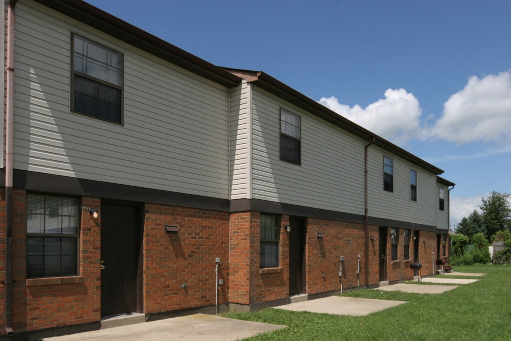 the side of an apartment building with brick and white siding