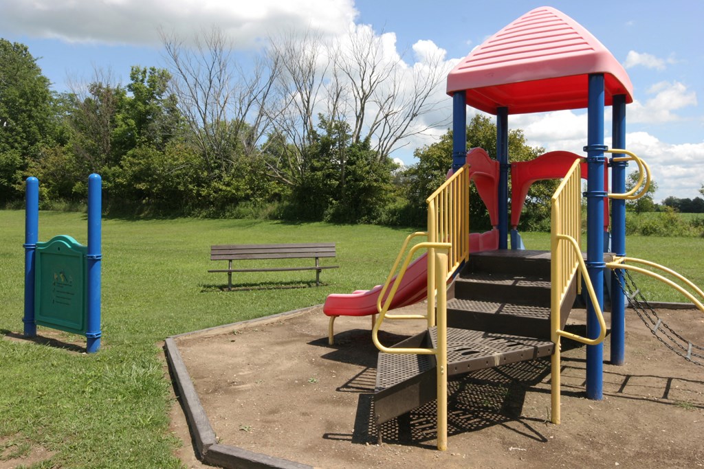 a playground with a play set and a bench in a park