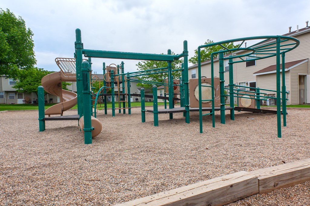 a playground with a slide and monkey bars in a park