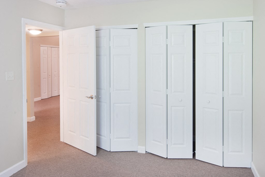 a row of white closet doors in a room