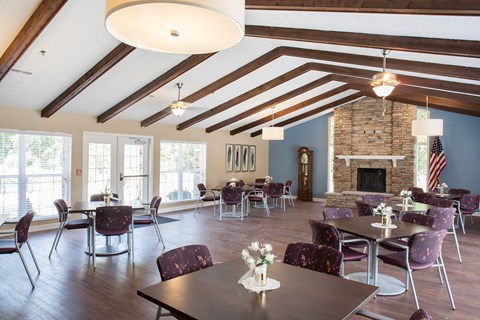 a large room with tables and chairs and a stone fireplace