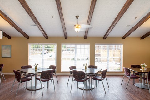 a dining room with tables and chairs and large windows