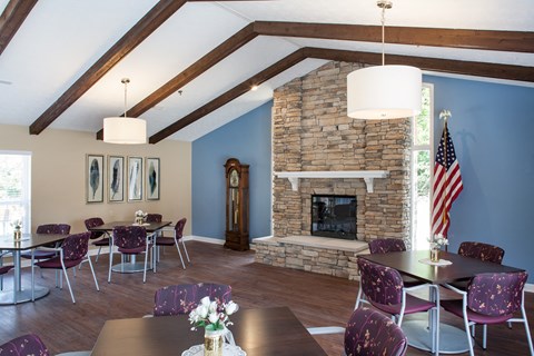 a dining room with a table and chairs and a stone fireplace