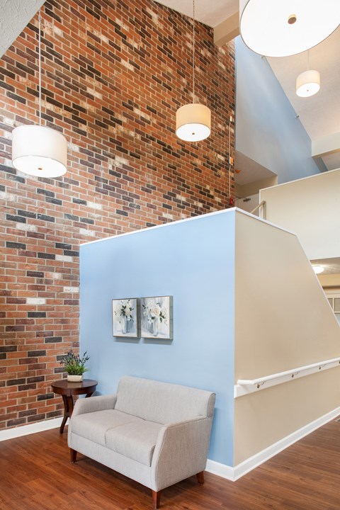 a living room with a couch and a brick wall