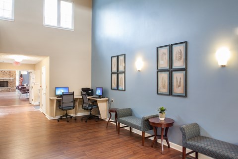 a living room with two computer desks and chairs and a fireplace