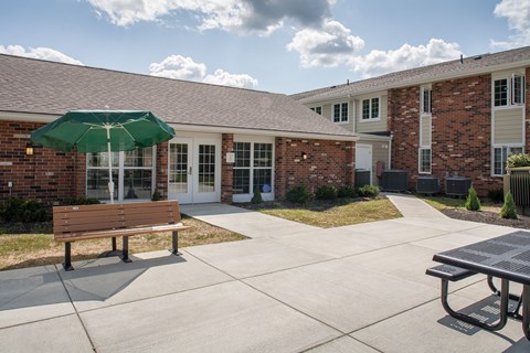 a courtyard with a bench and an umbrella in front of a building