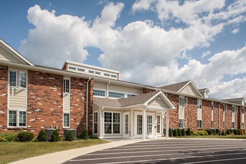 an exterior view of a brick building with white columns and windows