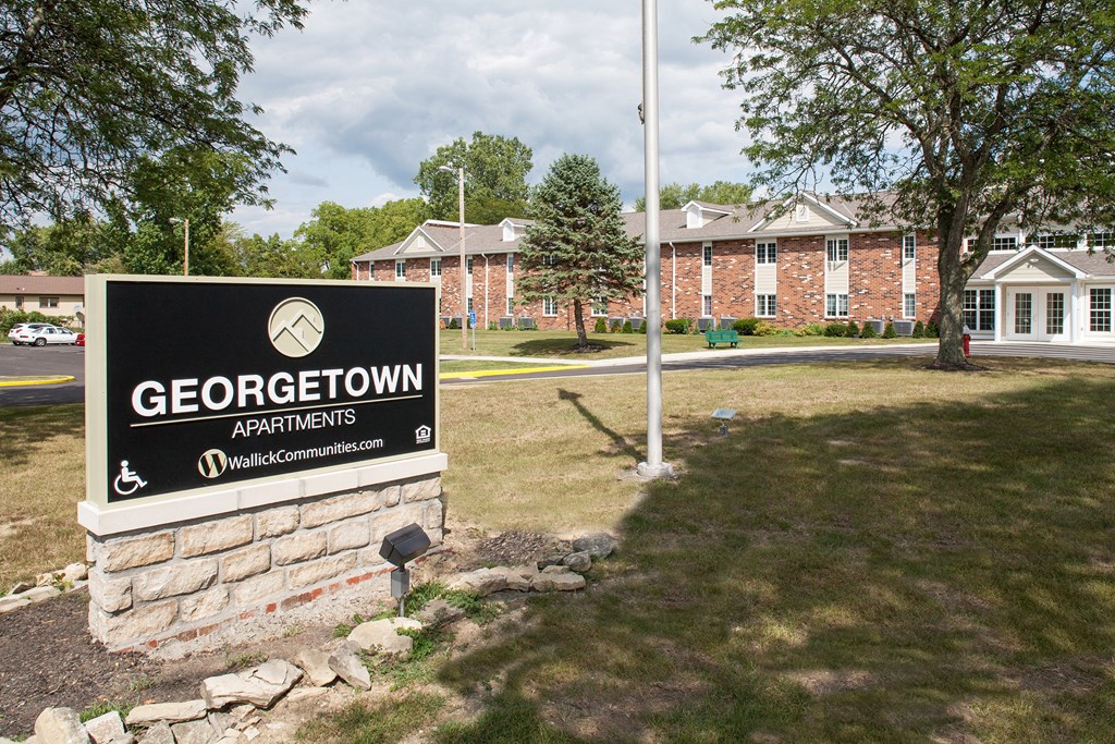 a sign for georgstown apartments in front of a brick building