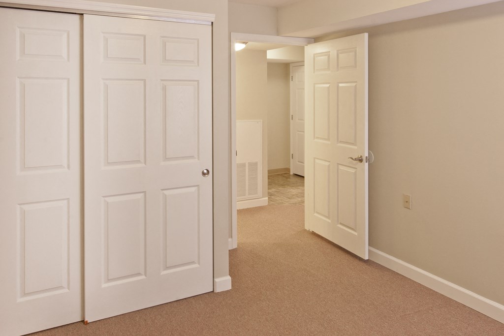 a bedroom with two closets and a door to a hallway