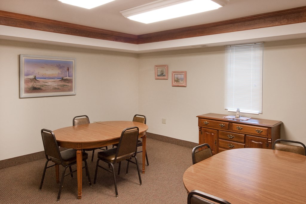 a conference room with a table and chairs and a dresser