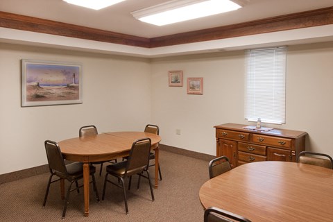 a conference room with a table and chairs and a dresser