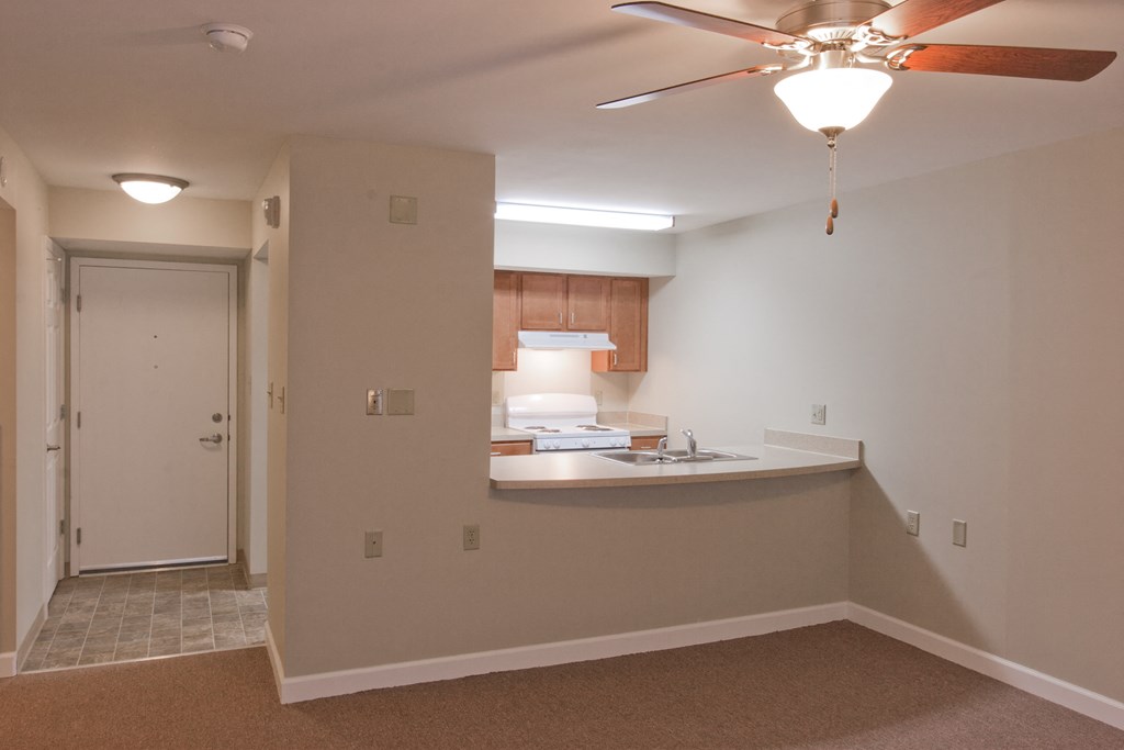 a view of a kitchen and a living room with a ceiling fan