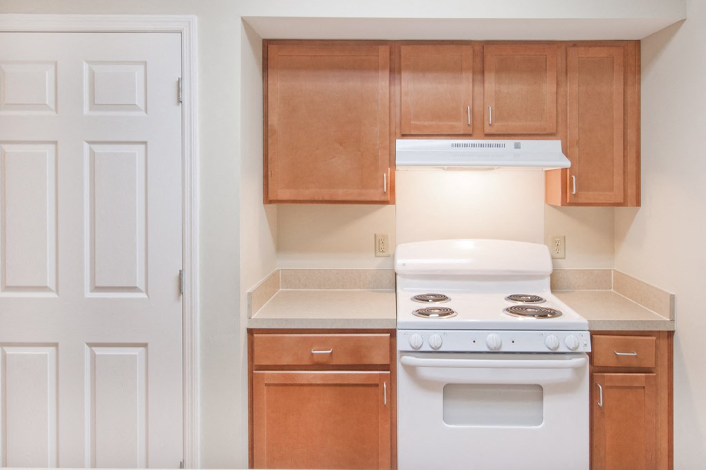 a kitchen with wood cabinets and white appliances and a white stove