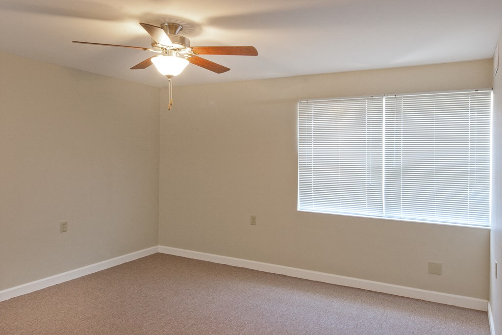 a bedroom with a ceiling fan and a window
