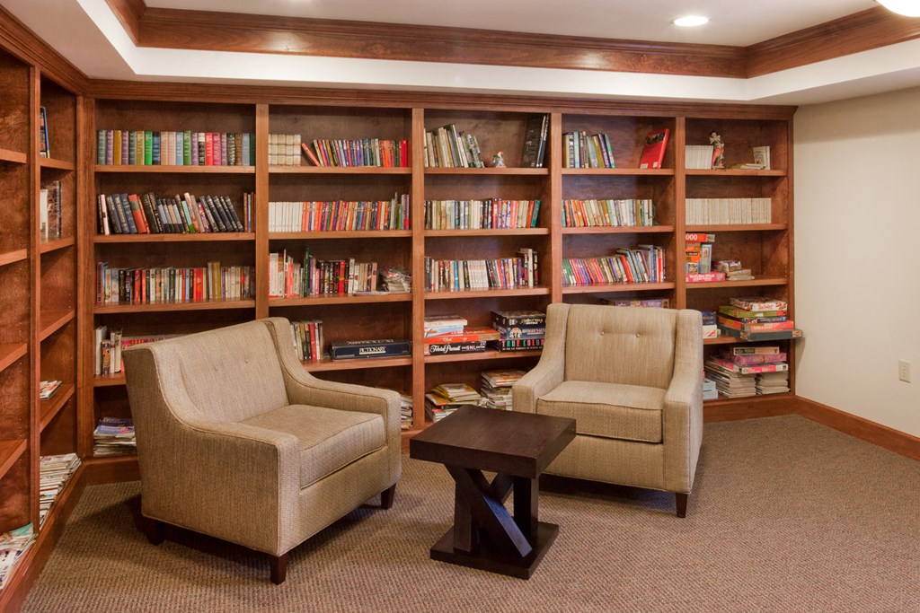 a library with two chairs and a coffee table