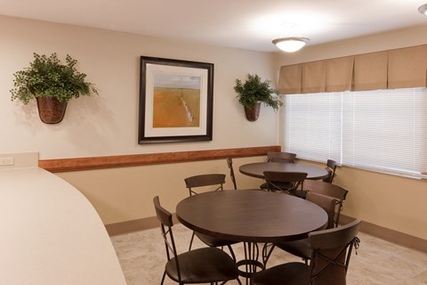 a dining room with tables and chairs and a painting on the wall