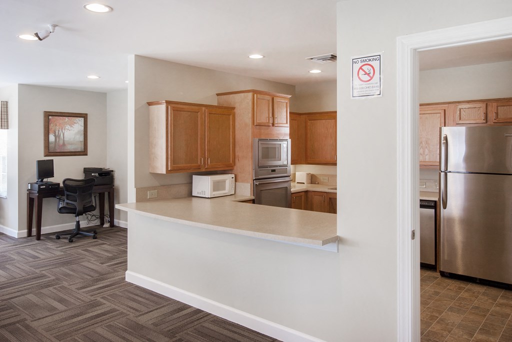 a kitchen with wooden cabinets and a stainless steel refrigerator