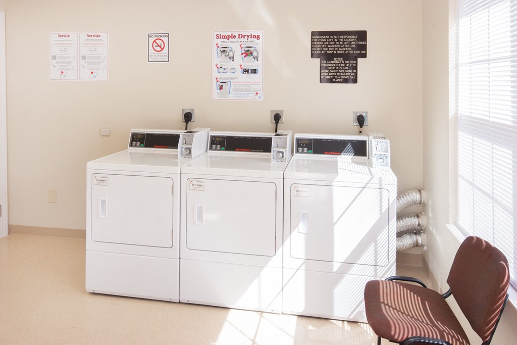 a laundry room with four washes and two dryers in it