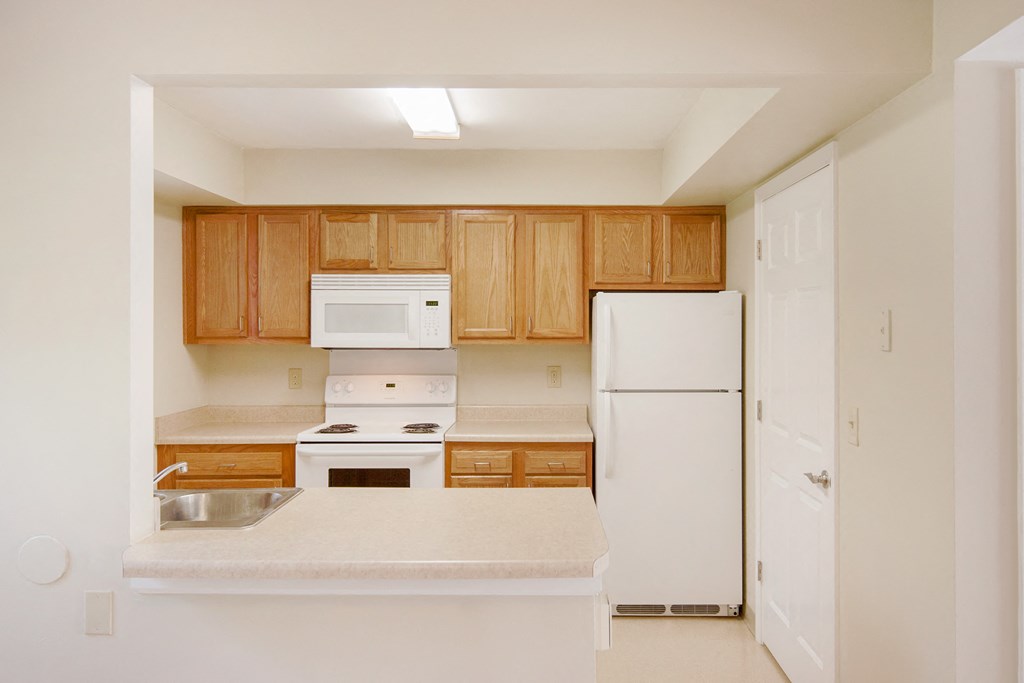 a kitchen with white appliances and wooden cabinets