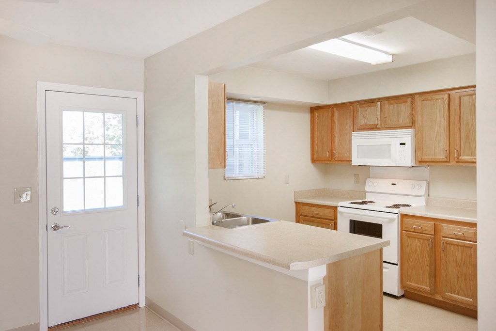 an empty kitchen with a sink and a white door