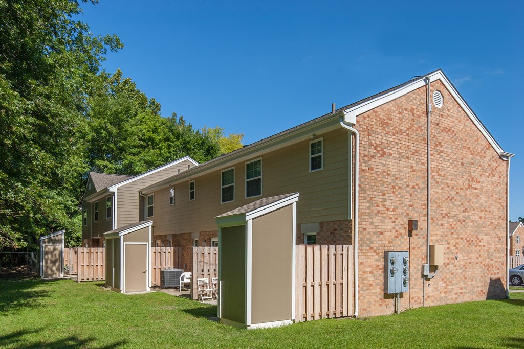 side view of a house with a yard and a fence