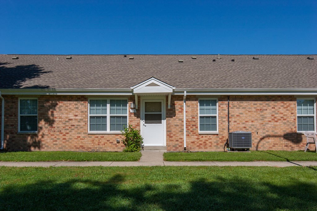the front of a brick house with a white door
