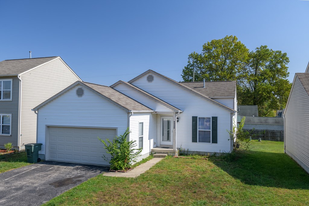 a white house with a garage and a lawn