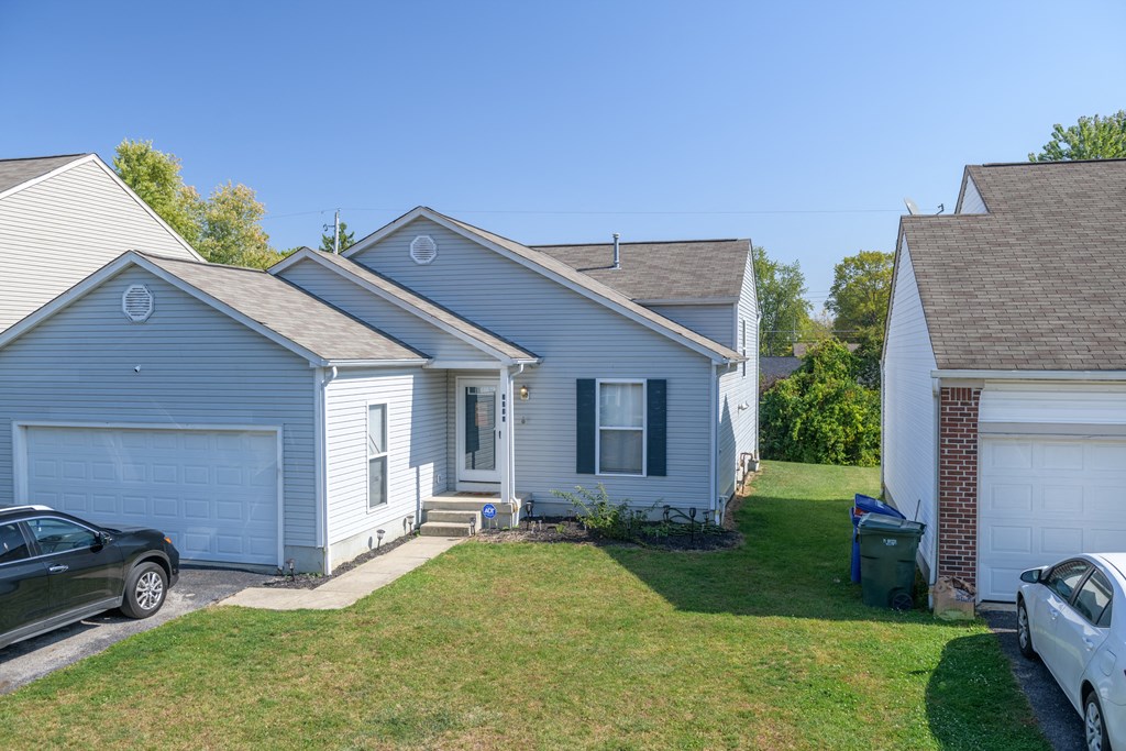 a blue house with a yard and a garage