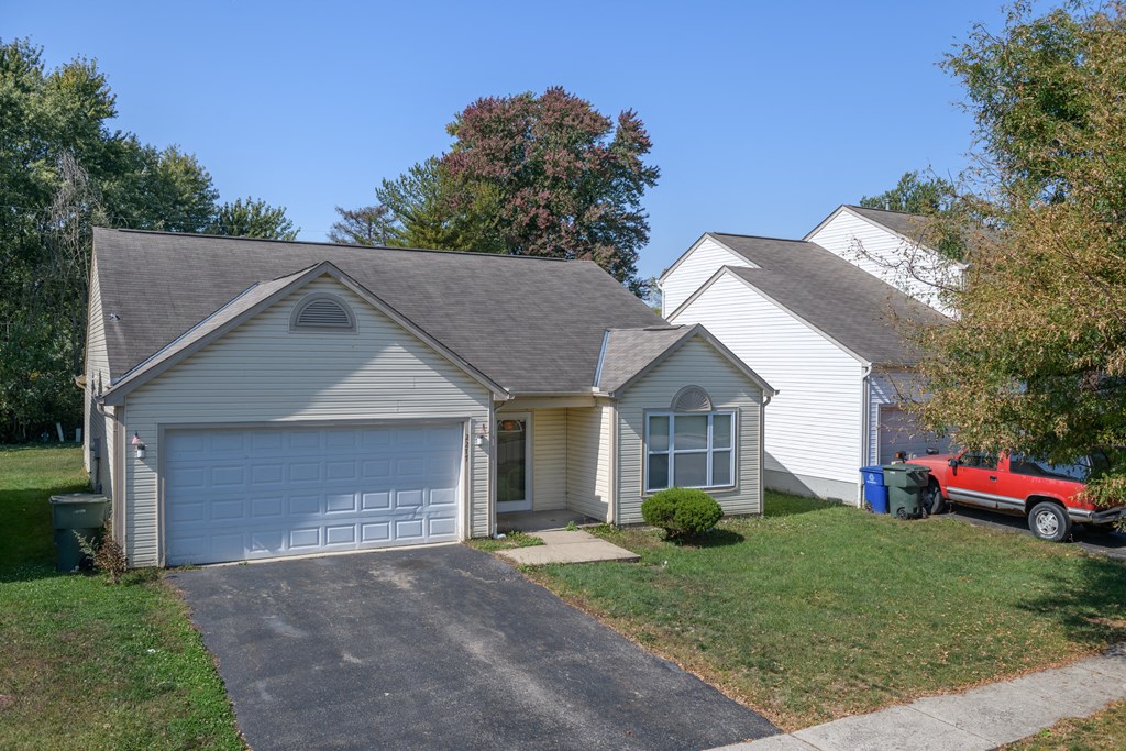 a white house with a garage and a red truck in the driveway