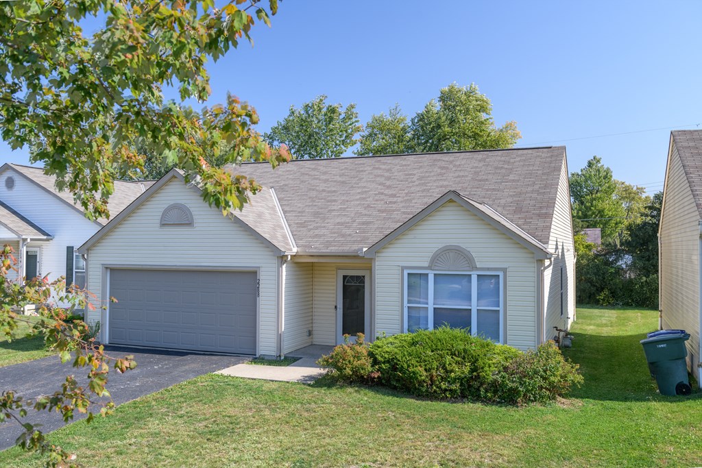 a white house with a gray garage door and a green lawn