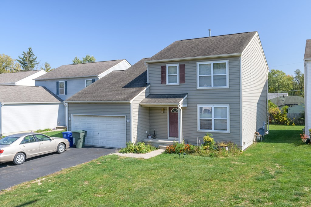 a gray house with a white car parked in the driveway