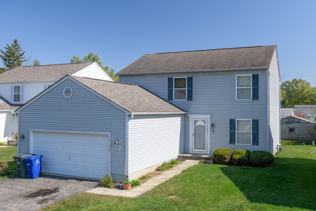 a blue house with a blue garage door and a lawn
