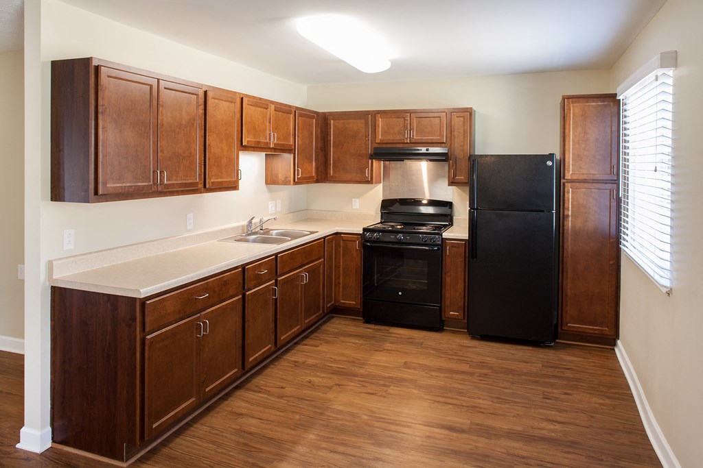 a kitchen with wooden cabinets and a black refrigerator