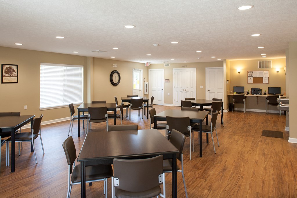 a dining room with tables and chairs and a kitchen