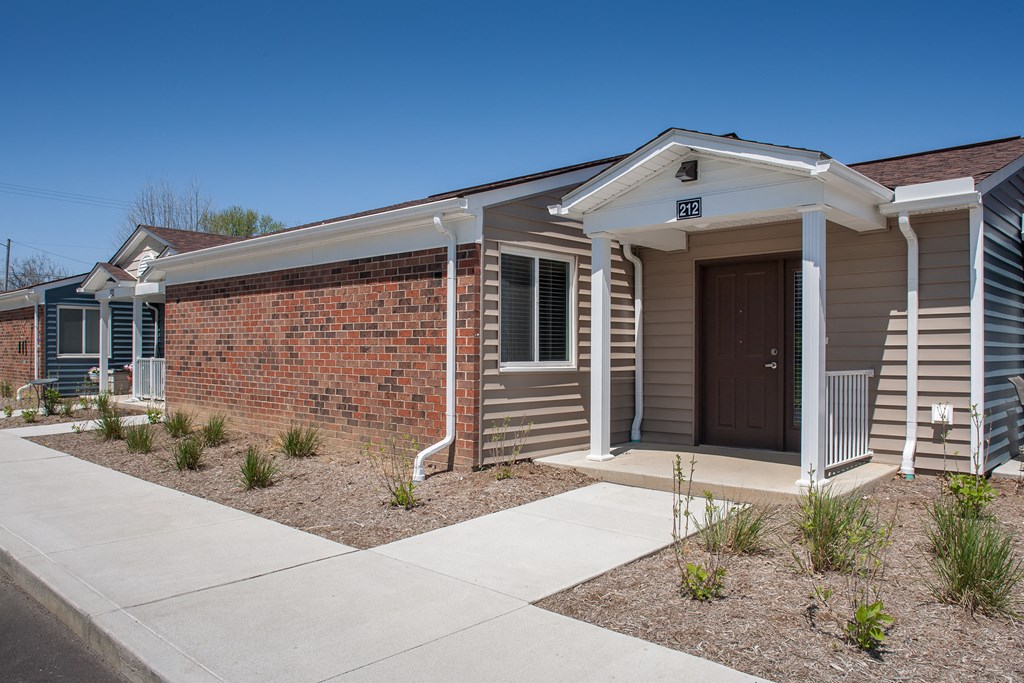 a small house with a sidewalk in front of it