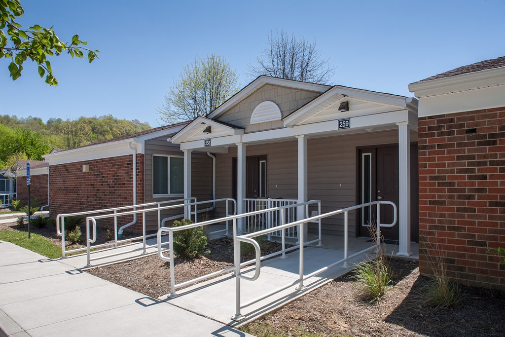 the front of a building with a ramp and a porch