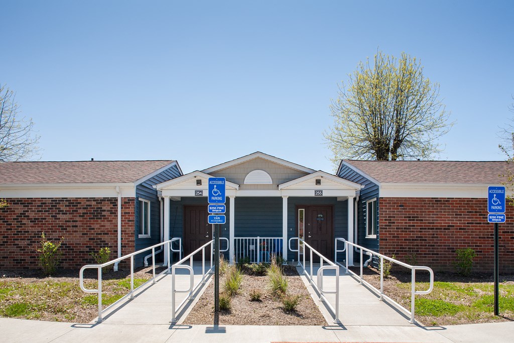 the front entrance of a building with ramps and a blue sign