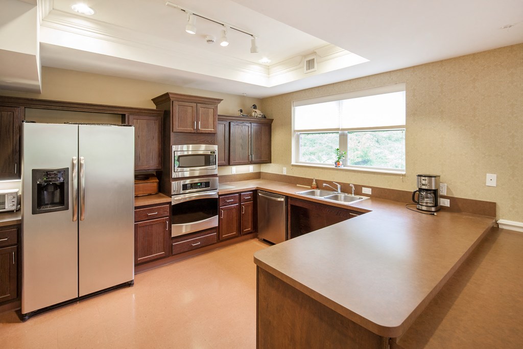 a large kitchen with stainless steel appliances and wooden cabinets