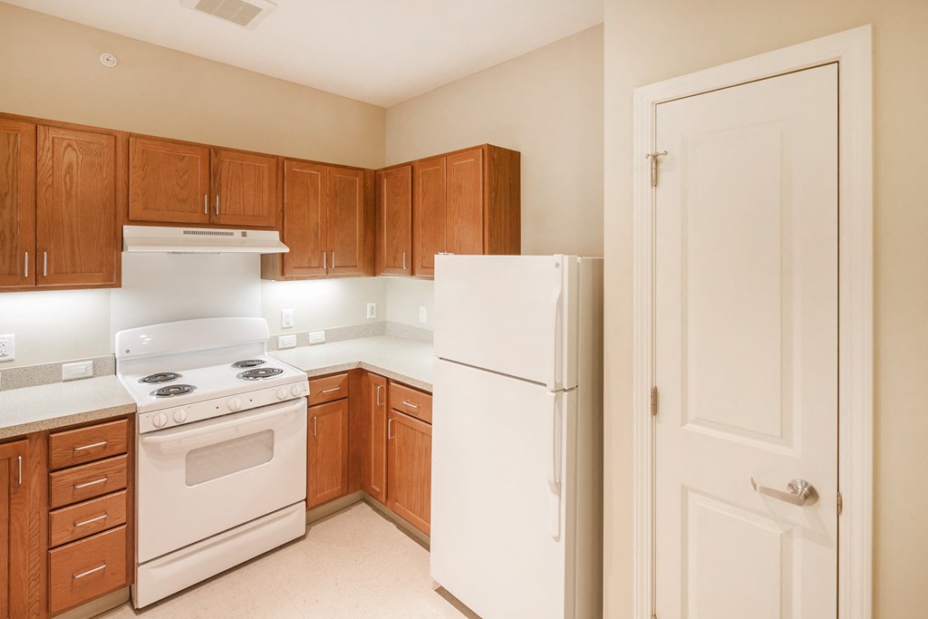 a kitchen with white appliances and wooden cabinets