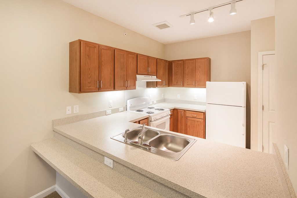 a kitchen with white appliances and wood cabinets