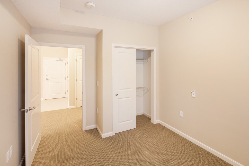 a bedroom with a closet and a door to a bathroom