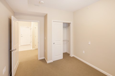 a bedroom with a closet and a door to a bathroom