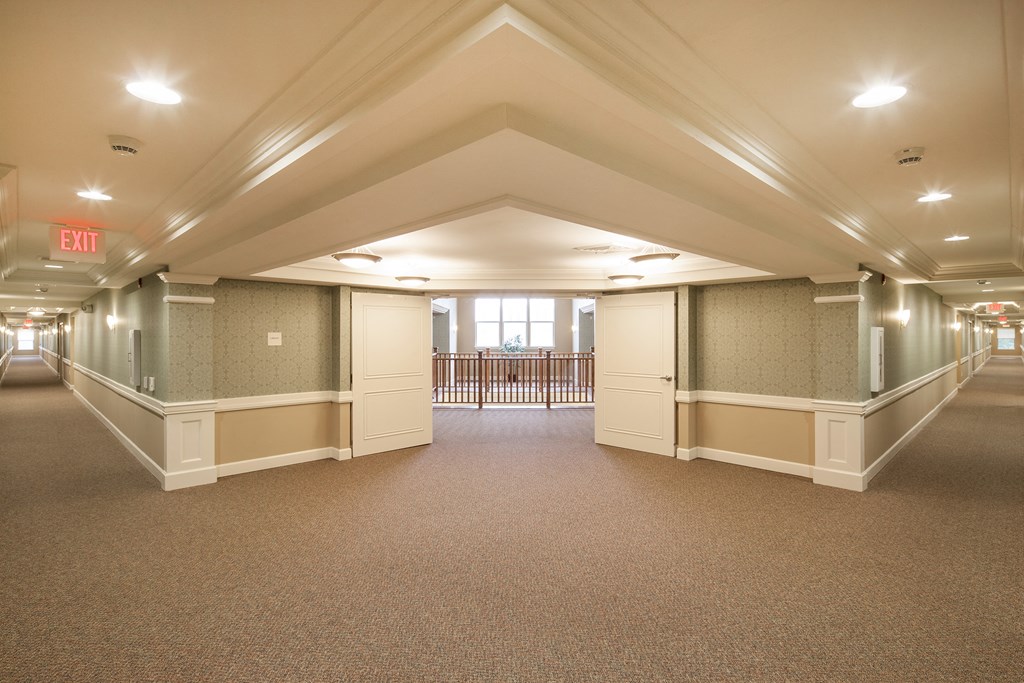 an empty room in a building with white pillars and a carpeted floor