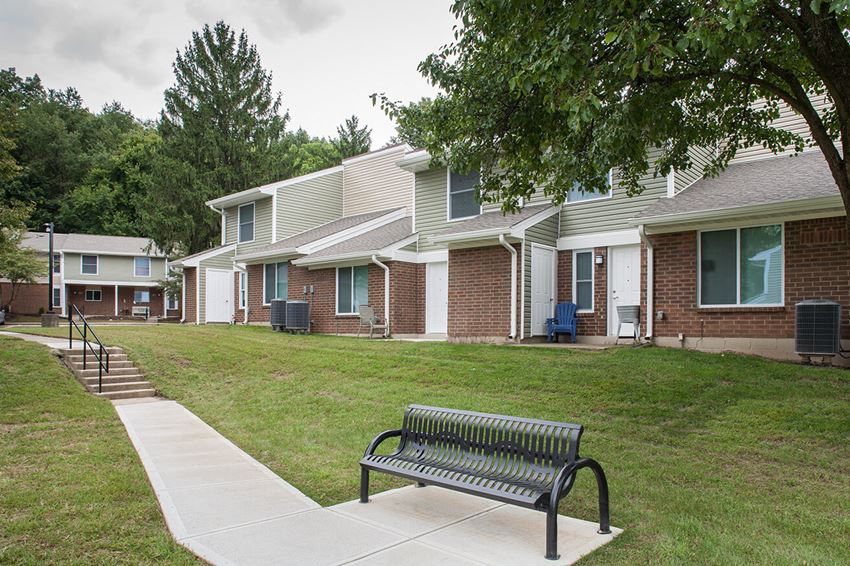 a park bench in front of a row of houses