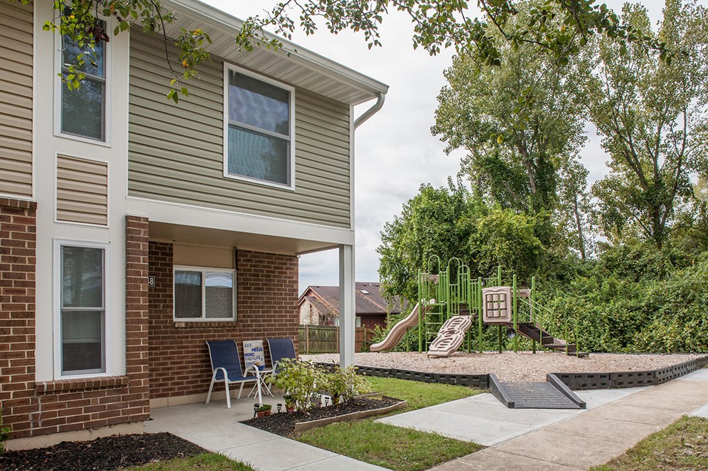 a patio in front of a house with a playground