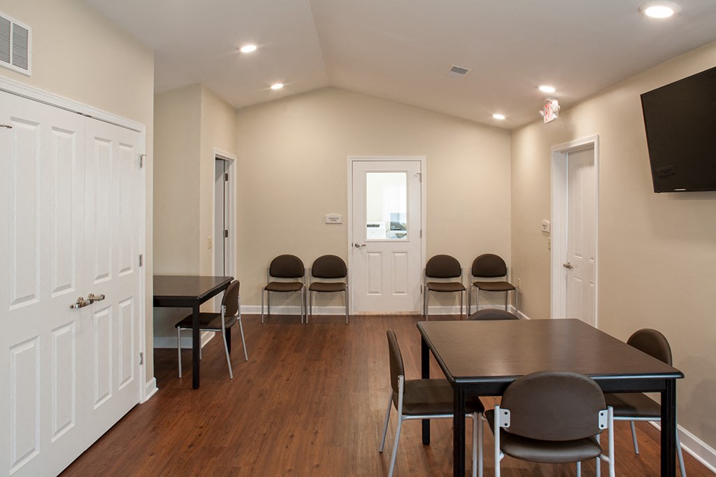 a conference room with a table and chairs and a television