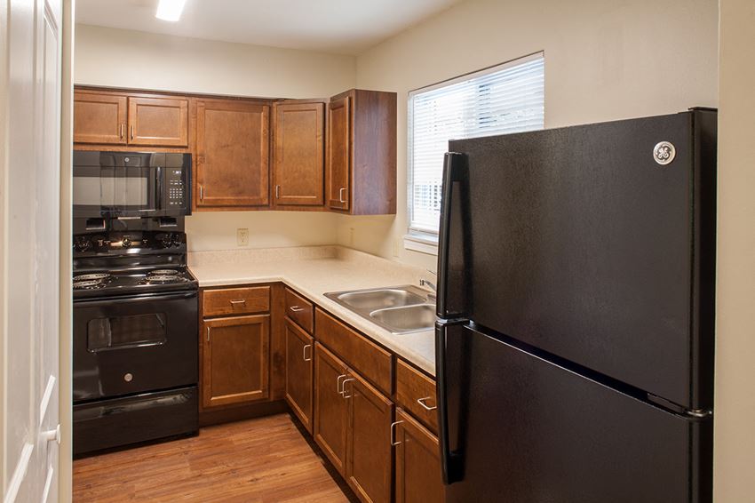 a kitchen with black appliances and wooden cabinets