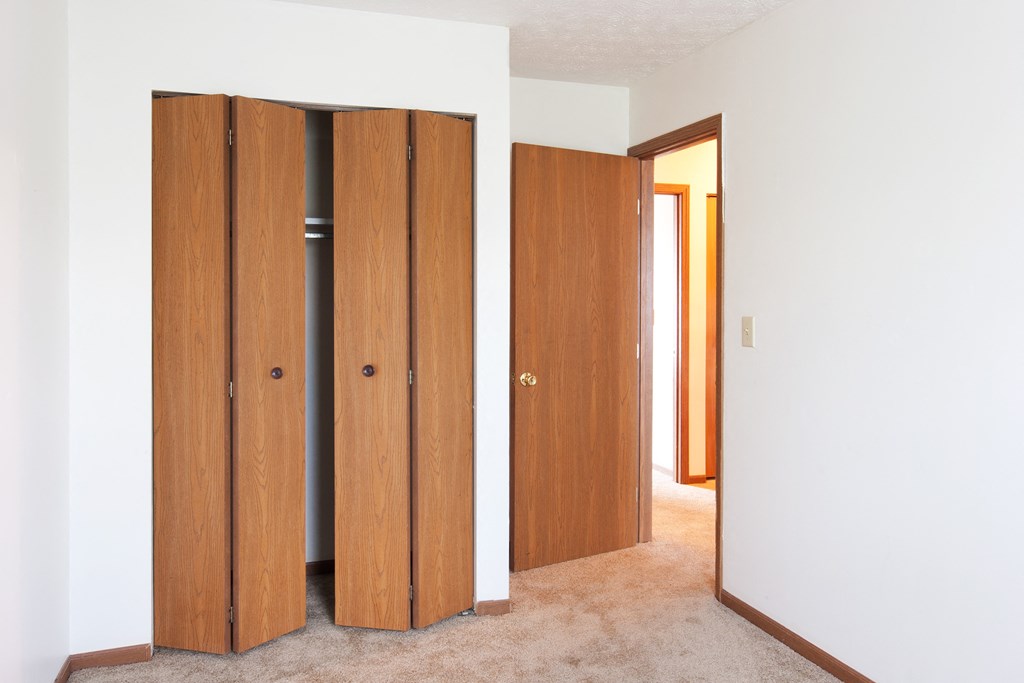 three wooden doors in a room with white walls and carpet