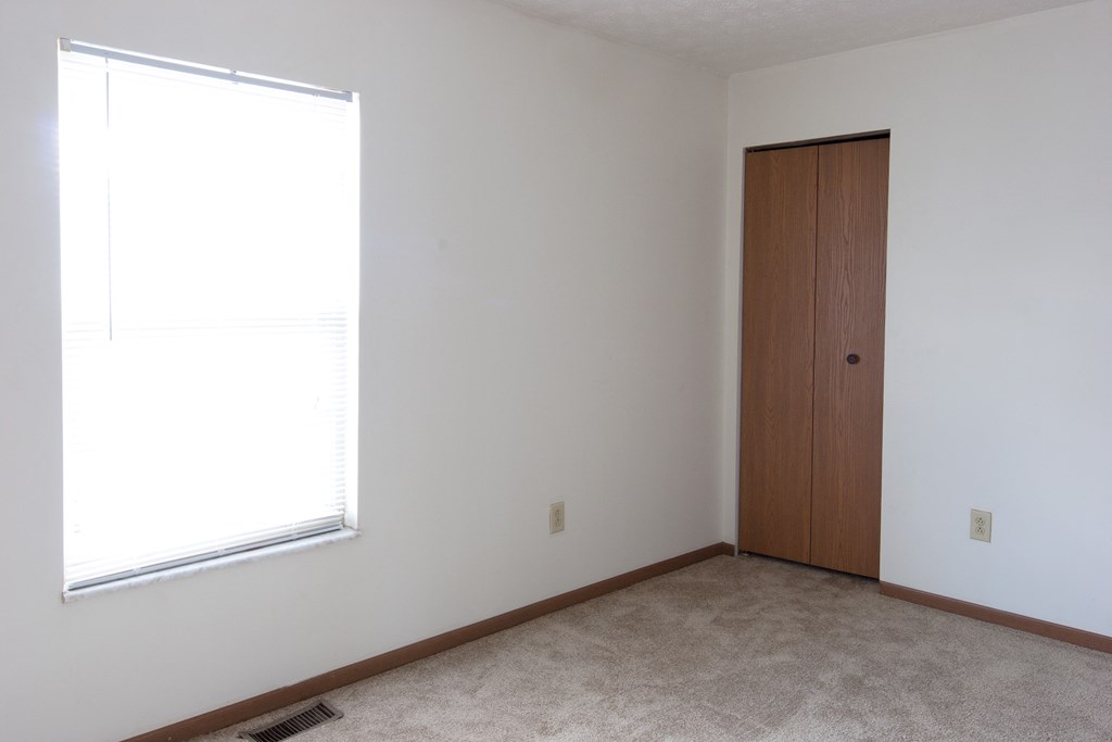 an empty room with a window and a door