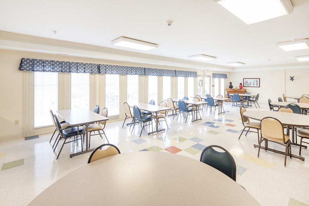 a large dining room with tables and chairs and windows